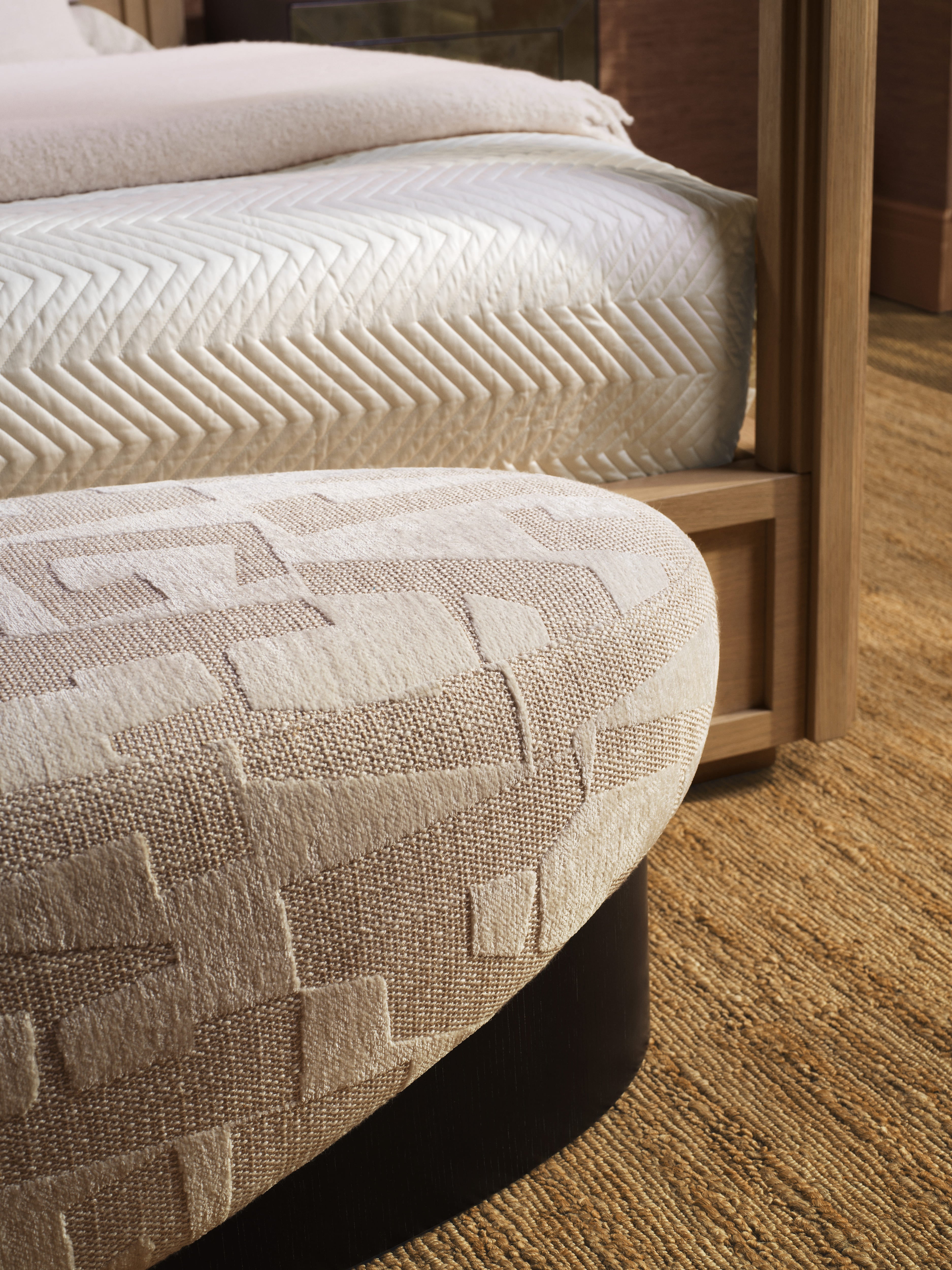 Detailaufnahme einer Eichholtz Sitzbank mit geometrischem Stoffmuster im luxuriösen Schlafzimmer.